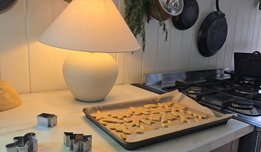 Image is of the gingerbread biscuits cut out ready to bake on a tray